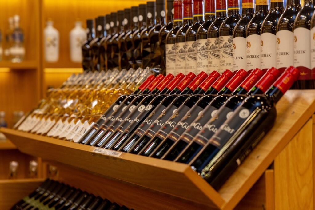 Mastering the First Impression: Your intriguing post title goes here Close-up of diverse wine bottles arranged on a wooden shelf display.